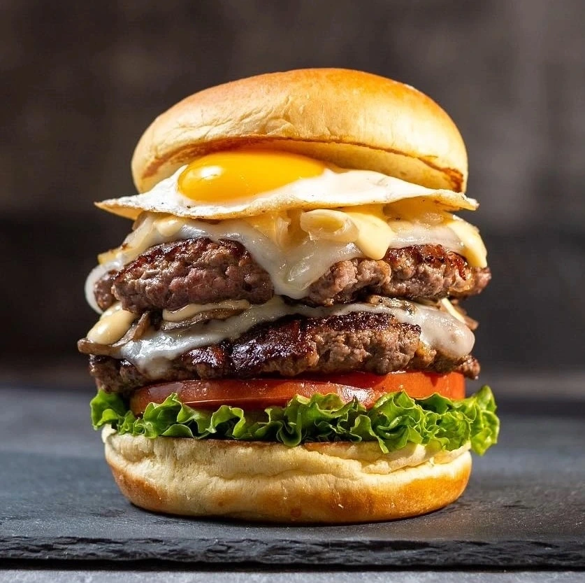 A Bullger team member presenting a plated burger